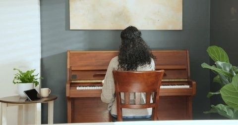Person övar piano hemma i en lugn vardagsmiljö